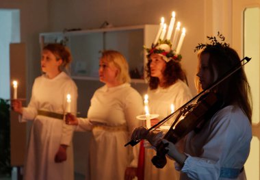 Stockholm, İsveç - 13 Aralık 2018: Lucia parade şarkı söyleyen kız beyaz elbiseler mum tutan ile. Saint Lucia Stokholm, İsveç, İtalya'dan acı 13 Aralık 2018 geleneksel kutlama