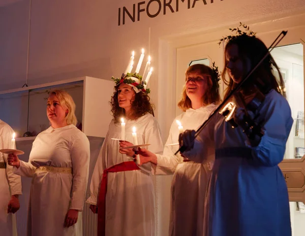 Stockholm, İsveç - 13 Aralık 2018: Lucia parade şarkı söyleyen kız beyaz elbiseler mum tutan ile. Saint Lucia Stokholm, İsveç, İtalya'dan acı 13 Aralık 2018 geleneksel kutlama