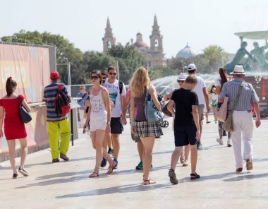 Valletta 'da eski taş sokaklarda yürüyen insanlar. Sıcak bir yaz. 
