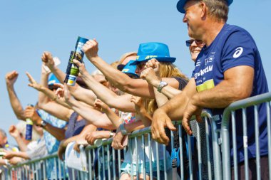 Seyirciler kollarını sallayarak dörtnala koşan Jo 'yu destekliyor.