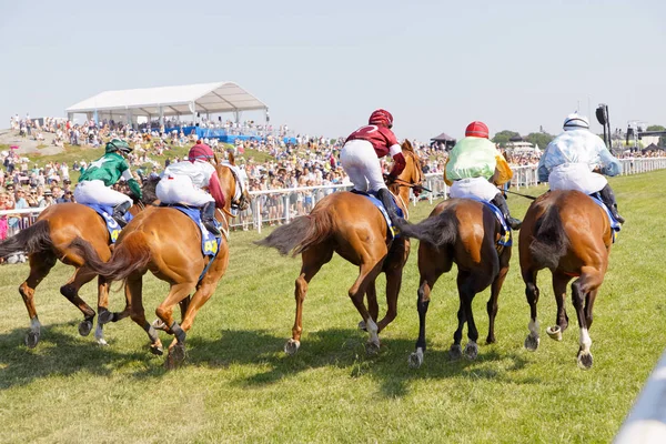 Rear view of colorful jockeys on race horses just after the star — Stock Photo, Image