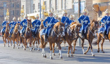 Kraliyet muhafızları mavi üniformalı, merkezde atın üstündeler.