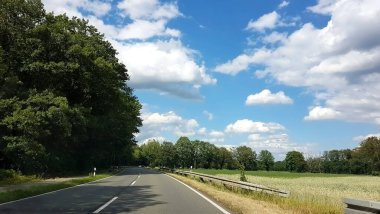 Ormanda yol mavi gökyüzü beyaz bulutlar