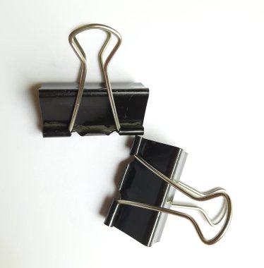 Beyaz arkaplanda düzenlenmiş iki siyah ataç ya da ataç