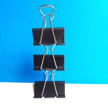 Dikey olarak beyaz ve mavi arkaplanda düzenlenmiş üç siyah ataç veya çerçeve.