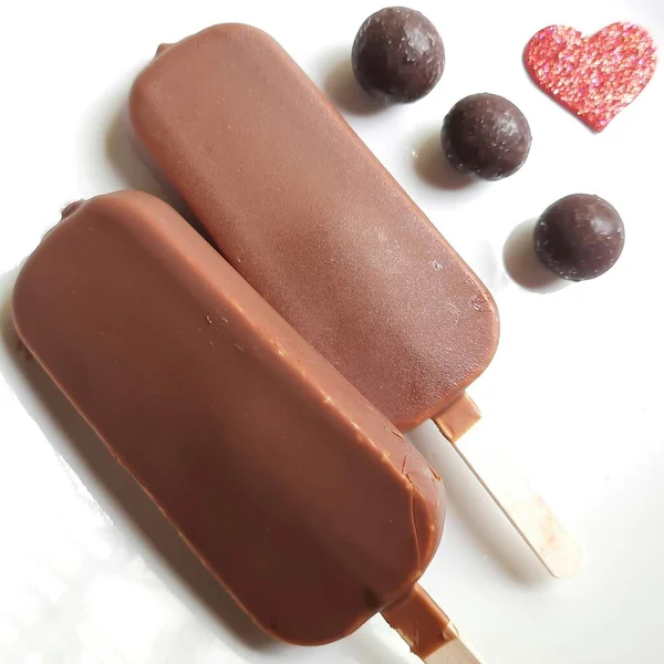 ホワイトプレートにチョコレートボールが美しくメッキされたおいしい2つのチョコレートアイスクリームバー — ストック写真