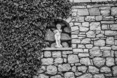 Taş duvar ve küçük melek heykeli