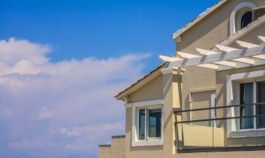 Pencereli ve mavi bulutlu gökyüzü olan ev balkonu