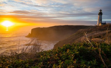 Newport, Oregon yakınlarındaki Yaquina Baş Deniz Feneri 'nin inanılmaz günbatımı