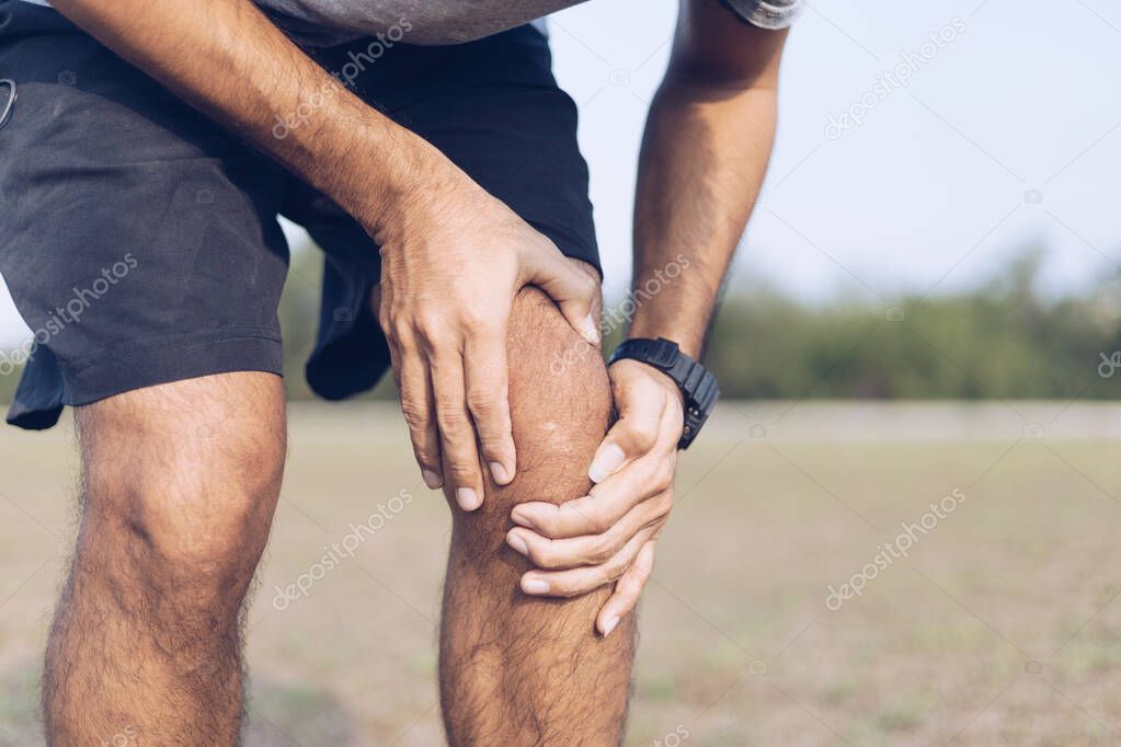 Young man hands knee injury while Exercise or running