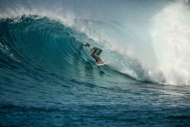 Mükemmel mavi dalgada sörfçü, fıçıda temiz su, Hint Okyanusu Maldivler adasına yakın Thulusdhoo
