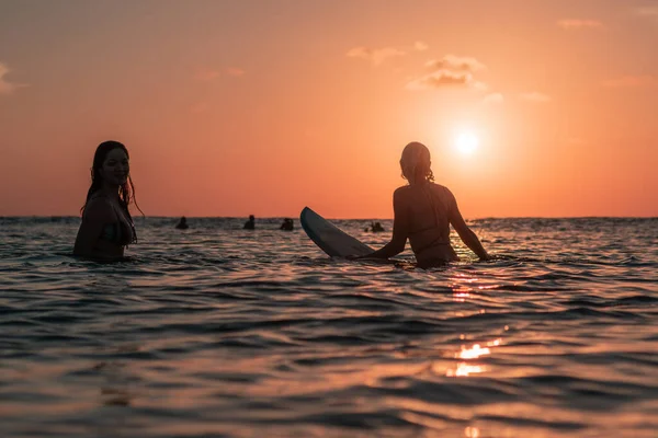 Bali Günbatımında Okyanusta Sörf Tahtasında Güzel Vücutlu Iki Sörfçü Kızın — Stok fotoğraf