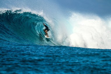Mükemmel mavi dalgada sörfçü, fıçıda temiz su, Hint Okyanusu Maldivler adasına yakın Thulusdhoo