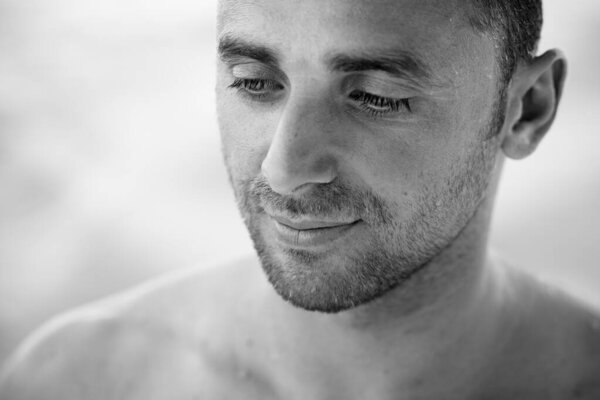 Портрет красивого мужчины, серфингиста, держащего доску для серфинга океана на заднем плане