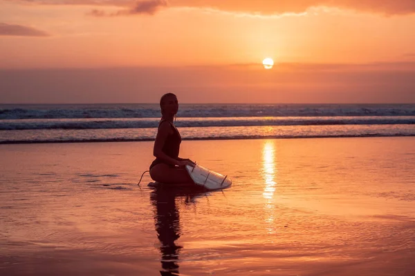 巴厘岛艳阳高照的冲浪女郎与冲浪板在沙滩上的画像 — 图库照片