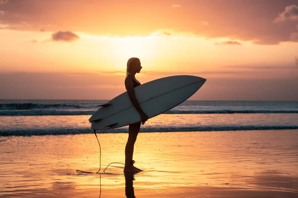 バリのカラフルな夕日の時間にサーフボードとビーチで美しい体を持つサーファーの女の子の肖像画 — ストック写真