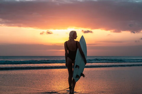 バリのカラフルな夕日の時間にサーフボードとビーチで美しい体を持つサーファーの女の子の肖像画 — ストック写真