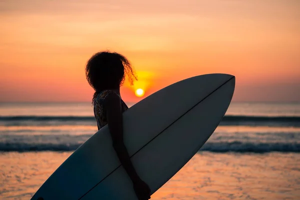 バリのカラフルな夕日でサーフボードとビーチで美しい体を持つ女性サーファーの肖像画 — ストック写真