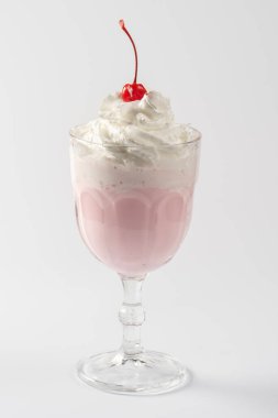 Beyaz tabakta krema ve kiraz şurubuyla vişneli süt karışımı..