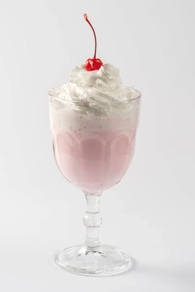 Beyaz tabakta krema ve kiraz şurubuyla vişneli süt karışımı..