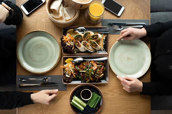 Masada bir kız ve bir erkek bir Asya restoranında akşam yemeği ya da öğle yemeği yiyorlar. Restoranda öğle yemeği. İki kişilik romantik bir yemek. Pekin ördeği ve baharatlı yemekler. Restoranda akşam yemeği..