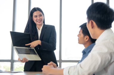 Asyalı kadın parmağını bilgisayarın boş ekranına doğrultuyor - iş sunumu konsepti