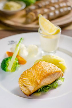 Yanında patates ve sebzeyle birlikte somon bifteği.