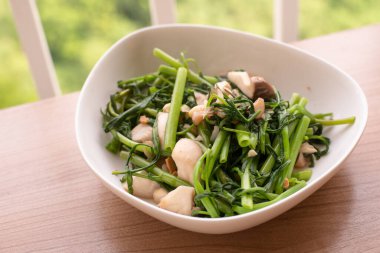 Kızarmış yeşil sabah zaferini sarımsak ve mantarla karıştır.