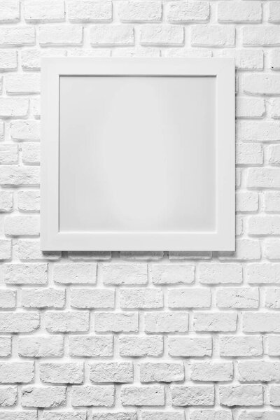 Blank paper frames on white brick wall in vertical