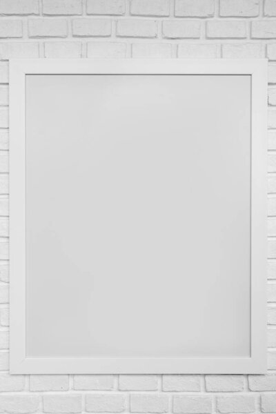 Blank paper frames on white brick wall
