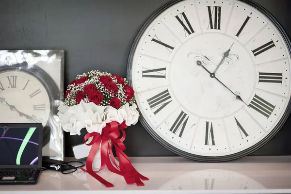 Romantik bir saatin yanında bir buket gül