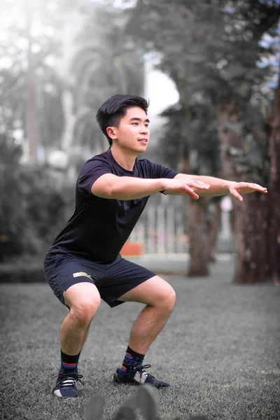 Asian Young Man Squat Excercise Park — Stock Photo, Image