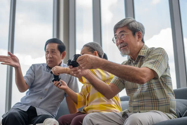 group of asian retired enjoy playing video game together in living room