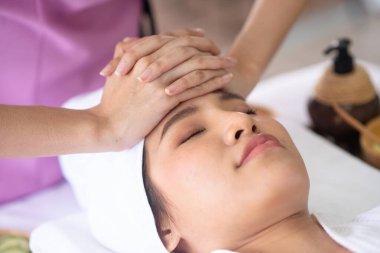 Terapist elini kullanarak müşterinin alnına dokunuyor.