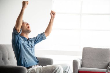 Kanepede kendinden emin bağıran bir adam.