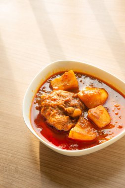 Tayland tavuğu, köri, Tayland tavuğu ve Hint cevizi sütü ve baharatlı patates, beyaz pirinçle yenir.