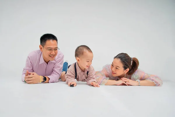 south-east - chinese asian parent  lie down on the floor play toy with their son