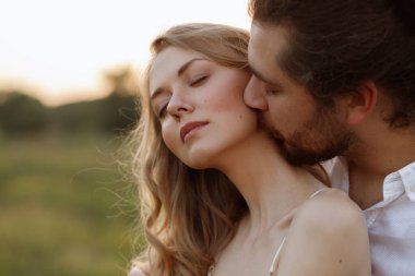 The guy kisses the girl in the neck. close-up portrait clipart