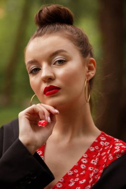 Parti için göz kamaştırıcı bir yaz makyajı. Model kameraya bakıyor. Kırmızı rujlu dudaklar. Bronzlaşmış ten