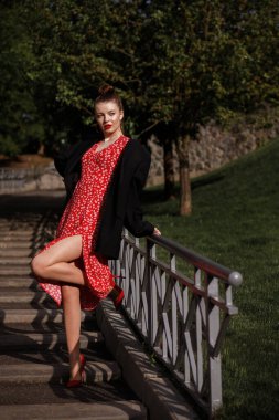 Yazın parkta yürüyüş yapan kırmızı elbiseli kız..