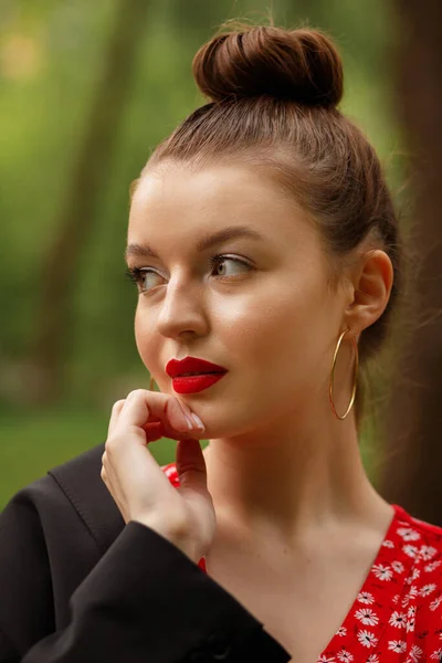 緑の背景の笑顔で夏の化粧と赤いドレスの女の子 — ストック写真