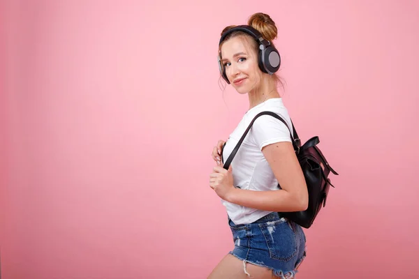 Sexy Vrouwelijke Student Hoofdtelefoon Met Een Rugzak Een Roze Achtergrond — Stockfoto