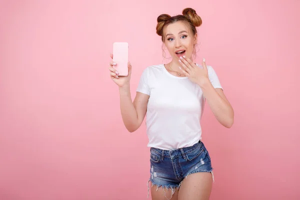Zaskoczona Dziewczyna Telefonem Różowym Tle — Zdjęcie stockowe