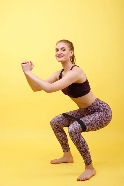 Sportmädchen Hockt Mit Gummiband Den Füßen Hintergrund — Stockfoto