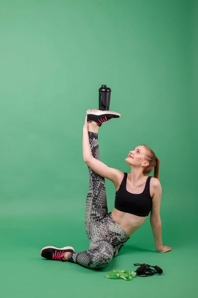 Sportlerin Streckt Sich Und Hält Auf Ungewöhnliche Weise Eine Wasserflasche — Stockfoto