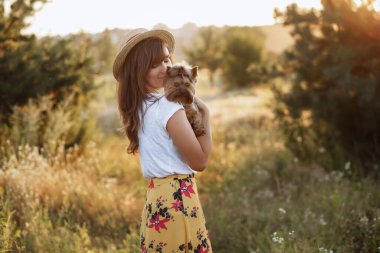 Model yazın gün batımında bir teriyer tutar.
