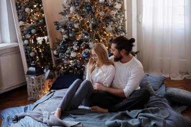 Noel ağacının yanındaki yatakta bir çift.