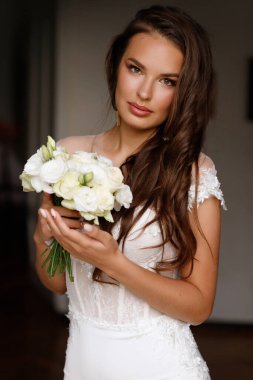 Makyajlı ve bir buket çiçekli gelin mutlu. Düğün organizatörü.