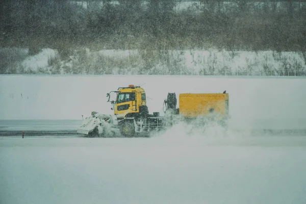 truck cleaning the heavy snow on the taxiway of airport