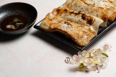 Çin yemeği, Çin yemeği (kızarmış hamur tatlısı) ve pembe arka planda Çin stili dekorasyonlar..